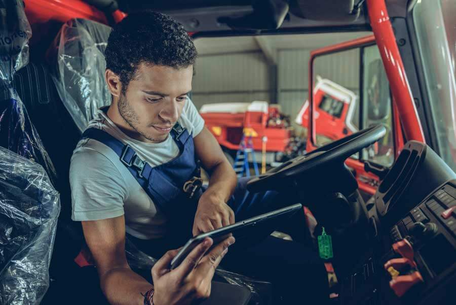 young-worker-checks-trucks-documentation-P4889DV - Fuel Logic Custom Creative Solutions